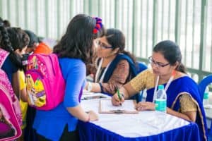 Teachers working at Babaji Vidhayashram School entering the details of students in a paper