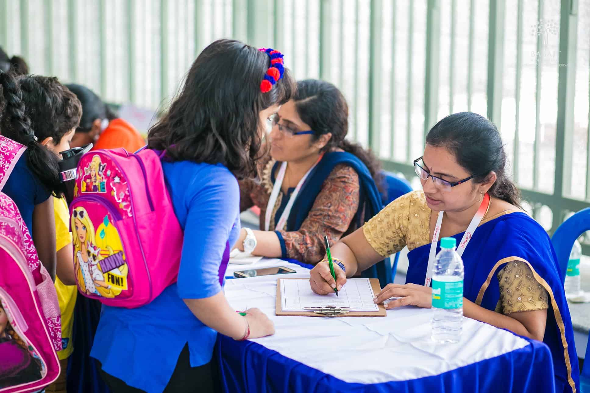 Teachers working at Babaji Vidhayashram School entering the details of students in a paper