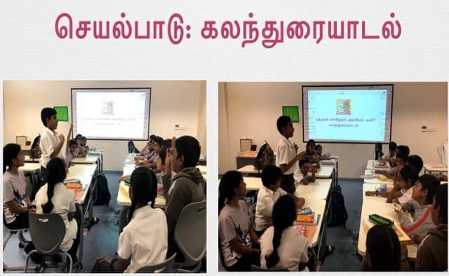 A group of school students are sitting on chairs, watching the big screen in front of them and involving in a group discussion.