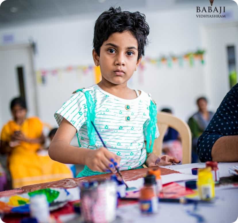 A young student of BVS engaged in painting.