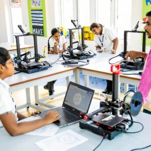 Three students are learning to work with 3D printing machine under the guidance of a senior teacher in a private school in Chennai.