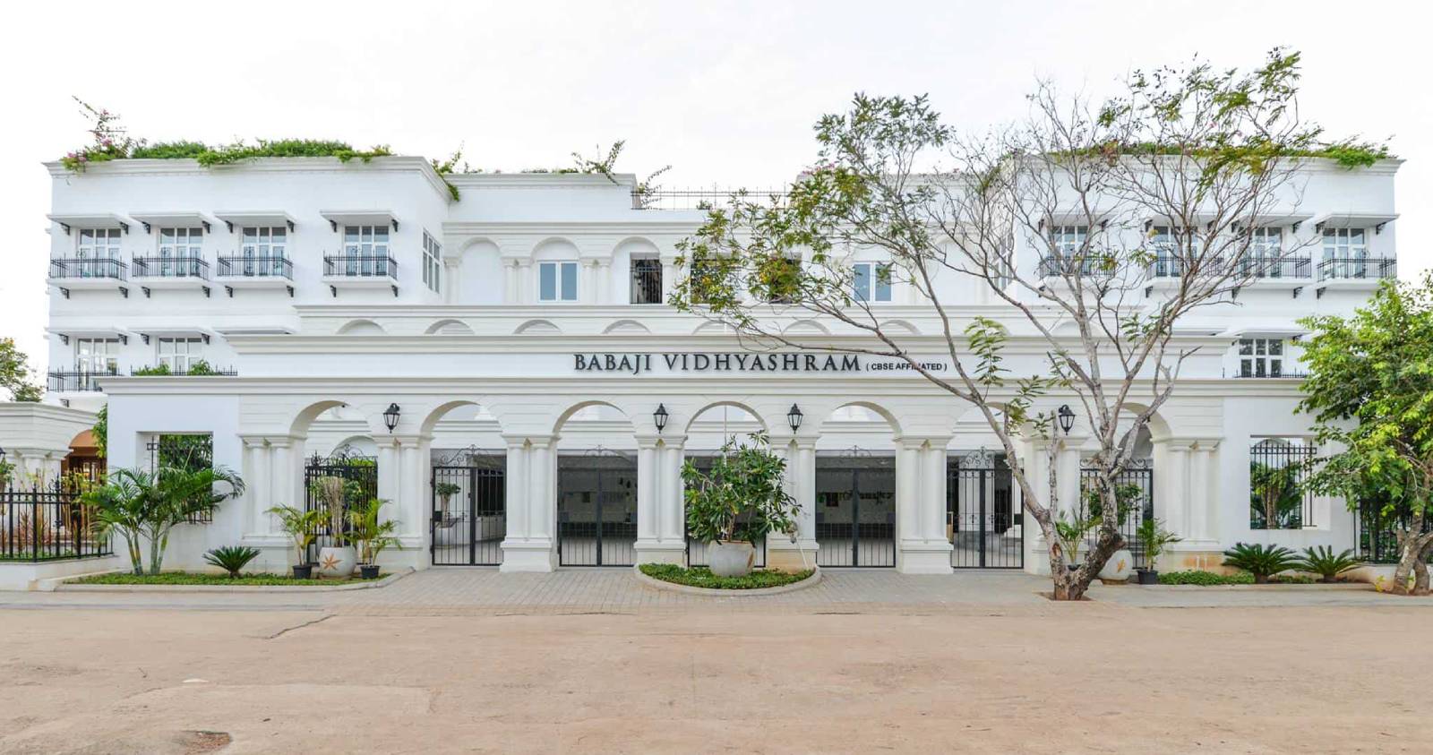 The complete front view of the magnificent buildings of Babaji Vidyashram in bright daylight.